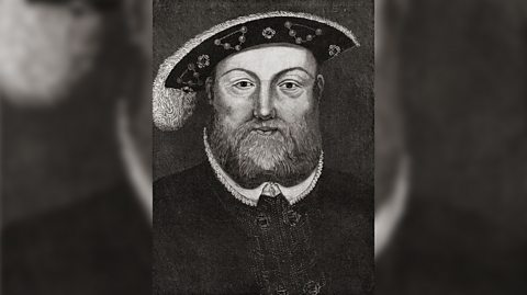 Një portret bardhë e zi i Mbretit Henri VIII. Ai ka një shprehje të zbrazët dhe mjekër të dendur, duke mbajtur një kapelë leshi në stilin Bristowe/Tudor me zbukurime pendësh.  