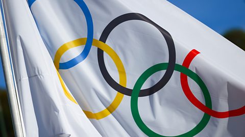 Olympic symbols on a flag at Panathenaic Stadium, Athens. The flag is white and the symbols are five circles intertwined - one blue, one yellow, one black, one green and one red
