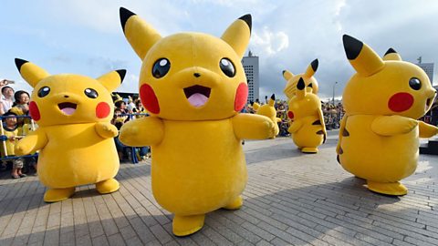 Four Pikachu mascots dancing in the street.