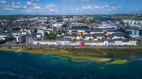 An aerial view of Galway city in Ireland, showing colourful houses on the waterfront