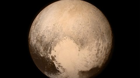 Pluto, a neutral coloured dwarf planet in space. The image was captured in 2015