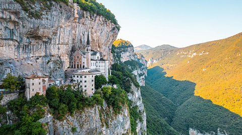 View of the Sanctuary of Madonna della Corona seemingly clinging to the side of a mountain