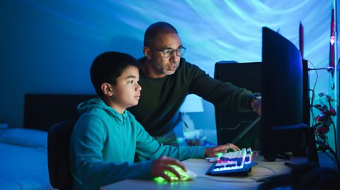 A parent and child looking at a computer screen