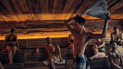 Nordik Spa Village An Aufgussmeister twirls a towel in a sauna as a crowd watches around him (Credit: Getty Images)