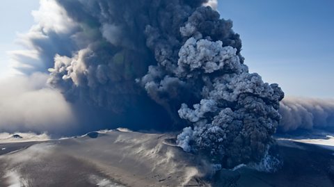 A volcanic eruption, with ash billowing out from the volcano