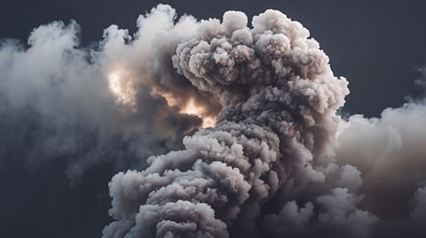 Massive volcanic eruption with thick white ash cloud rising against a dark black sky.