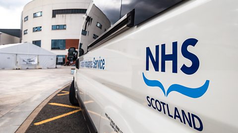A Scottish Ambulance Service vehicle parked close to the main entrance of a hospital