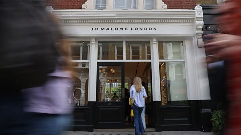 A woman walks into the front door of a Jo Malone London store