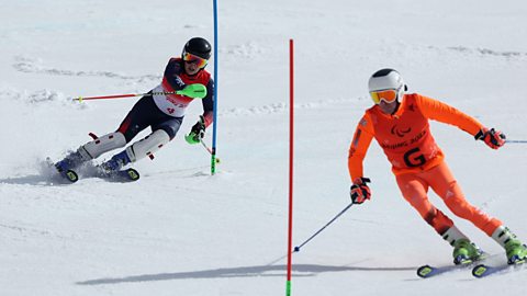 Visually impaired skier Menna Fitzpatrick takes part in a downhill slalom event with her guide, in all orange, ahead of her