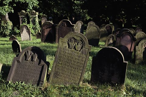 Gravestones with Hebrew writing on them in a graveyard