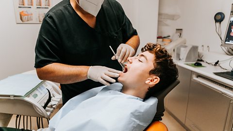 A young man having his teeth checked at the dentist