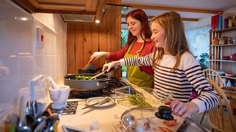 Teen sisters cooking together in the kitchen