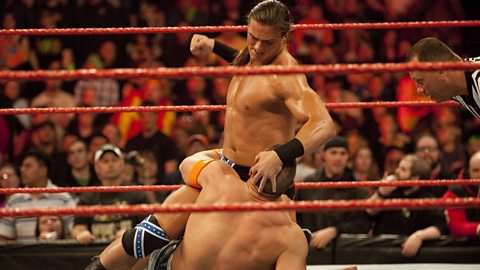 Drew McIntyre is stood over a prone John Cena, a fist clenched ready to strike