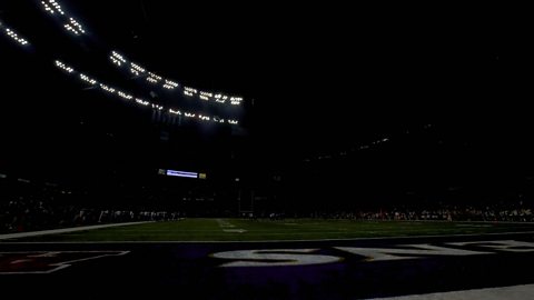 A shot of a stadium in near total darkness after a power failure. Some lights are visible above the far stand