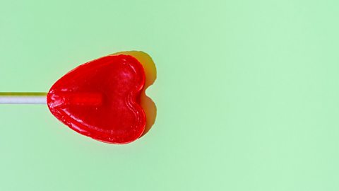 A red lollipop in the shape of a heart