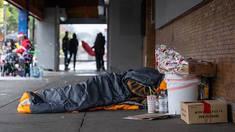 A homeless person lies on the street in San Francisco.