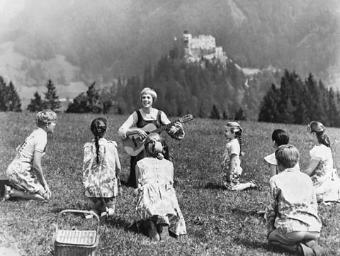 Julie Andrews and the cast of The Sound of Music filming against mountain backdrop