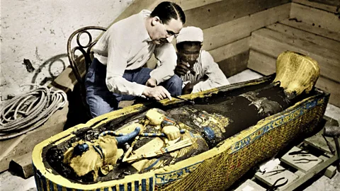 Alamy Howard Carter and his assistant crouching by sarcophagus (Credit: Alamy)