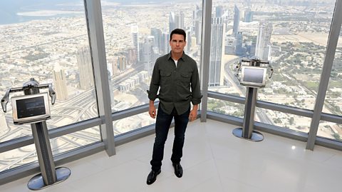 Tom Cruise on the 124th floor of the Burj Khalifa, with views of the city behind him