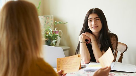 A mother helps her daughter study using flashcards