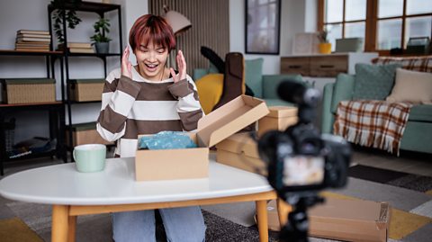 Excited teenager films themself opening a brown box