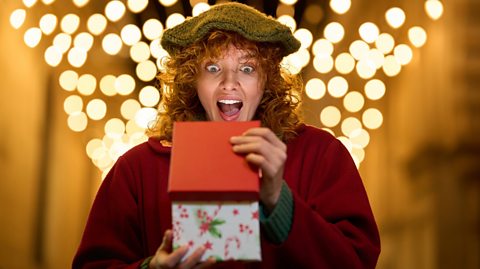 A young woman opens a box with a shocked expression