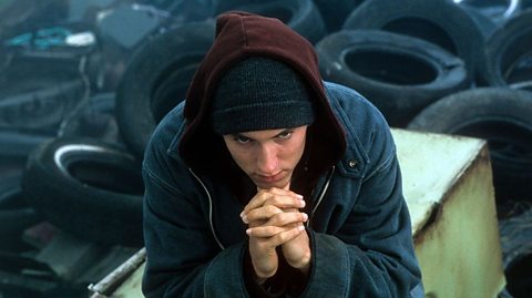 Eminem sitting in junkyard in a scene from the film 8 Mile from 2002