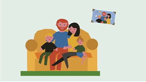 A green background with a family sat on a brown sofa