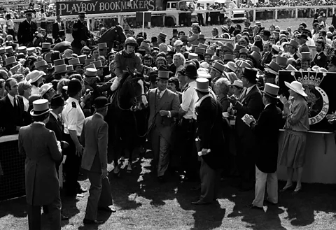 Alamy A man riding on Shergar amongst a crowd of people at the races (Credit: Alamy)