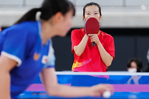 Alamy Chinese competitor Sun Boyao holds her table tennis bat in front of her face while playing against yamad Moemi of Japan at the Deaflympics in Tokyo (Credit: Alamy)