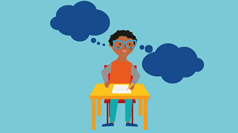 A young boy sat at a desk with two blue thought bubbles