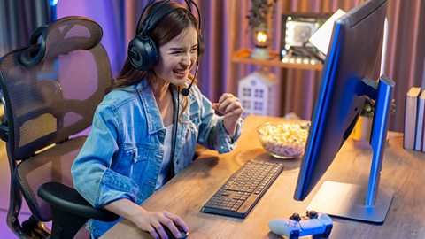Young girl playing computer game on laptop at night