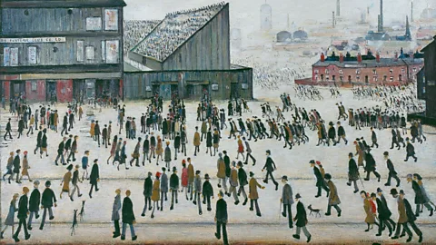 The Estate of L.S. Lowry L. S Lowry's painting 'Going to the Match' (1953). It's a painting of a large square with hundreds of people pouring into a Bunden Park stadium, with the skyline of Bolton in the background (Credit: The Estate of L.S. Lowry)