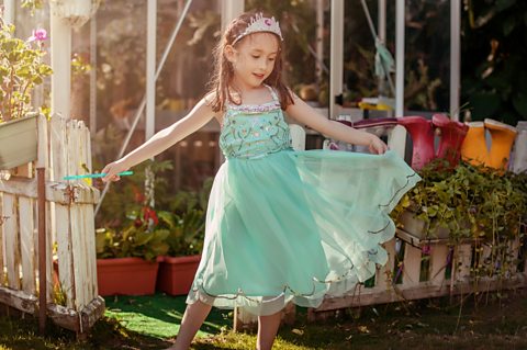 Image of a girl playing in the garden. Learning about adverbs is useful for pupils studying adverbs for the SEAG transfer test
