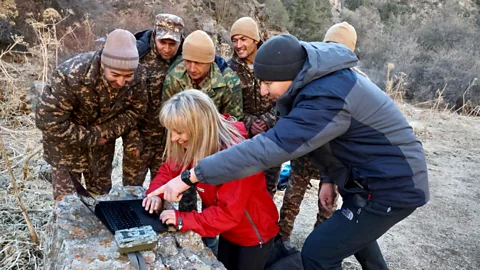 India Latham Wildlife presenter Michaela Strachan and a team of rangers review camera trap footage on a laptop which shows a snow leopard's movements in the Tian Shan mountain range in Uzbekistan (Credit: India Latham)
