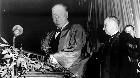 Alamy Winston Churchill in a robe at a lectern, with Harry S Truman standing behind him (Credit: Alamy)
