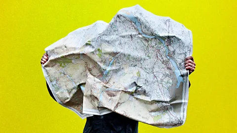 BBC/ Getty Images A person trying to read a crumpled map as the wind blows it against their face (Credit: BBC/ Getty Images)