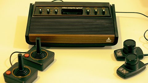 The black and brown Atari 2600 console, with two joystick attachments and two rotating knob attachments for Pong