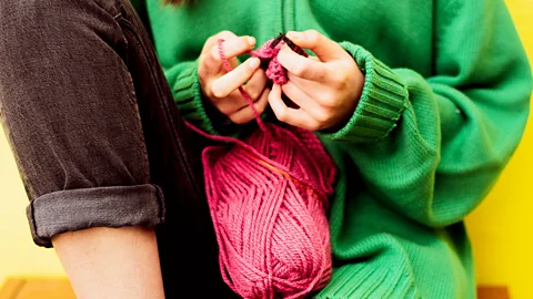 Getty Images Close up of a woman's hands knitting with bright pink wool (Credit: Getty Images)