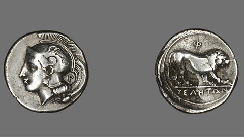 Two old silver coins. One coin shows the goddess Athena wearing a helmet. The other coin shows a lion walking