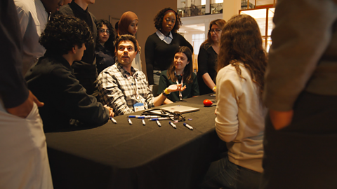 A representative from Imperial College speaking about AI with a group of students.