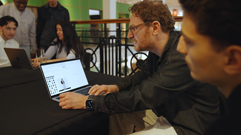 A representative from ASOS showing how to use AI with a group of students.