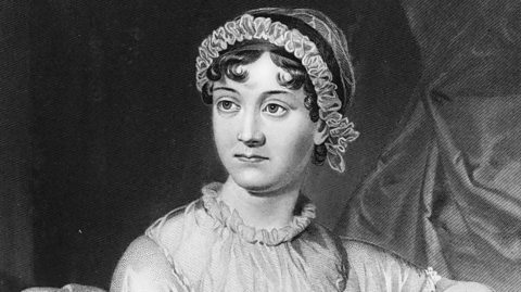 A black and white portrait of Jane Austen, who wears a white short sleeved dress with ruffle details on the sleeves and colour. Her hair is in a bun and she has a matching ruffled headband