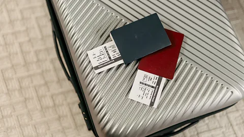 Getty Images Two passports and boarding passes on top of a silver hard-shell suitcase (Credit: Getty Images)