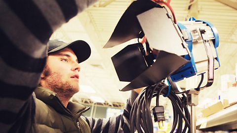 A man fixing a light on set