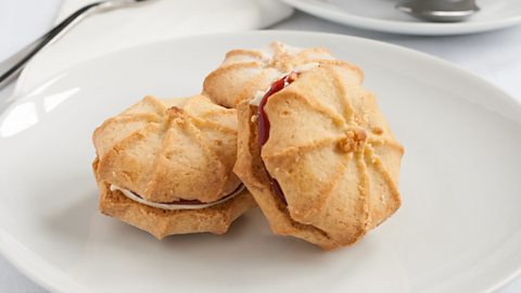 Three Viennese Whirl biscuits overlapping on a white plate