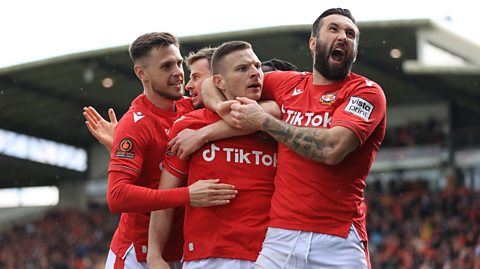 Wrexham's Ollie Palmer puts his arm around Paul Mullin and screams with delight after a goal