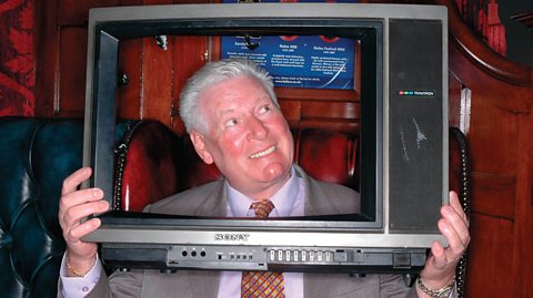 Roy Walker poses with his head inside the empty shell of an old television unit