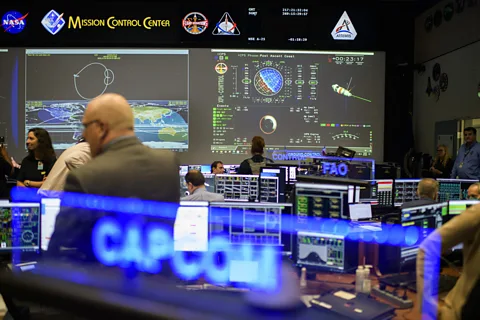 Getty Images Artemis Mission Control, a modern room with many desks and screens facing one large central screen covered in information (Credit: Getty Images)