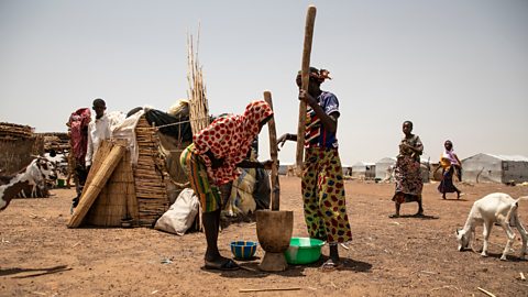 Displaced women pound millet at the Torodi IDP displacement camp in Dori.